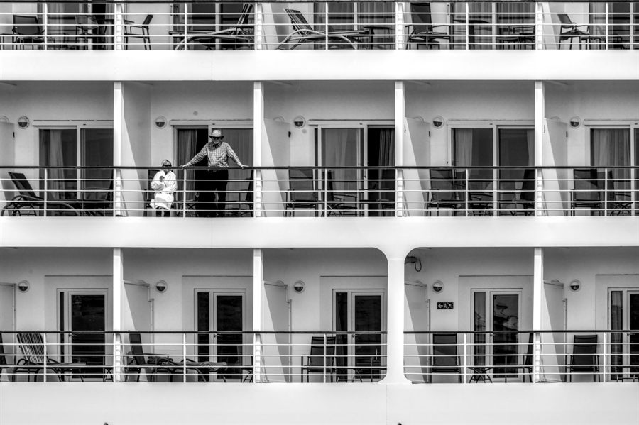 Two guests relaxing on a cruise ship balcony, in black and white